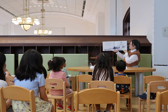 A library staff member reading from a picture book